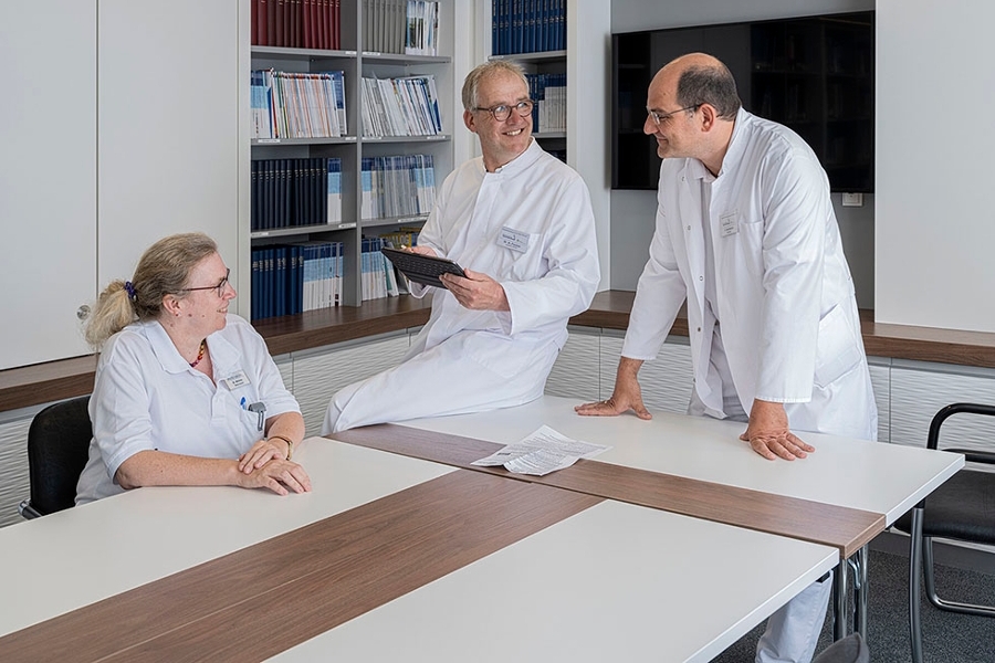 Ärztlicher Direktor Dr. med. Harald Fischer (Mitte) spricht sich mit seiner Kollegin und seinem Kollegen ab. Ärztlicher Direktor Dr. med. Harald Fischer (Mitte) spricht sich mit seiner Kollegin und seinem Kollegen ab.