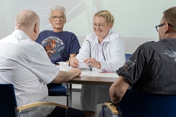Eine Ärztin spricht mit drei Patienten. Eine Ärztin spricht mit drei Patienten.